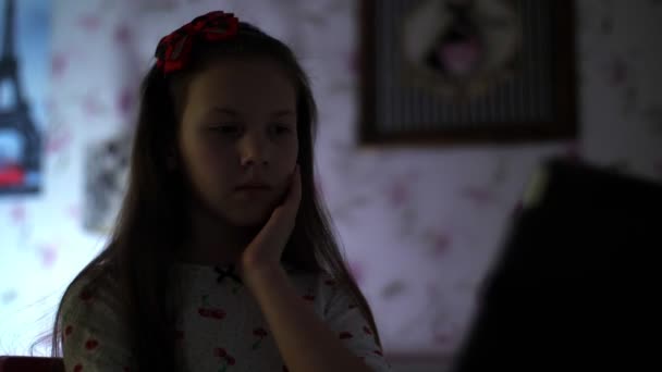 Dziewczynka w piżamie ogląda straszny film, horror na laptopie, w nocy, w sypialni. portret — Wideo stockowe