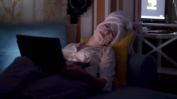 Portret, vrouw in cosmetische stof masker en witte handdoek op haar hoofd, viel in slaap voor laptop scherm, tijdens het werken of tv kijken 's nachts. vermoeide zakenvrouw — Stockvideo