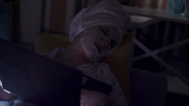 Portret, vrouw in cosmetische stof masker en witte handdoek op haar hoofd, viel in slaap voor laptop scherm, tijdens het werken of tv kijken 's nachts. vermoeide zakenvrouw — Stockvideo