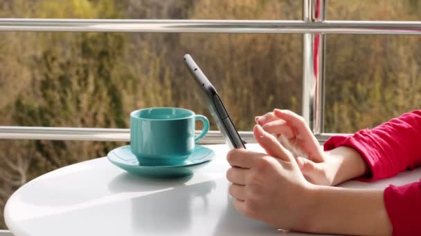 Close-up de mãos, adolescente digitando, trabalhando em tablet, na varanda aberta. primavera dia ensolarado . — Vídeo de Stock