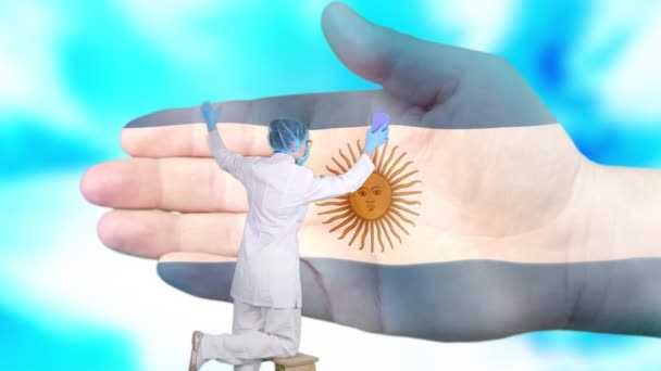 Krankenschwester mit medizinischer Maske und Handschuhen wäscht große Hand, bemalt in den Farben der argentinischen Flagge. Der Staat sorgt für die Gesundheit der Nation. Waschen Sie sich die Hände. Virenschutz. Prävention von Krankheiten. — Stockvideo