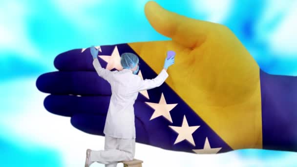 Krankenschwester mit medizinischer Maske und Handschuhen wäscht große Hand, bemalt in den Farben der Flagge von Bosnien und Herzegowina. Der Staat sorgt für die Gesundheit der Nation. Waschen Sie sich die Hände. Virenschutz. Prävention von Krankheiten. — Stockvideo
