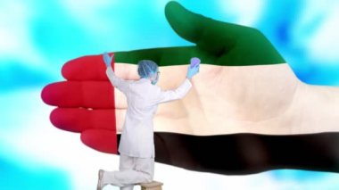 Tıbbi maskeli ve eldivenli hemşire, Birleşik Arap Emirlikleri bayrağı renginde boyanmış büyük elleri yıkıyor. Ulusal sağlık hizmetleri. Ellerinizi yıkayın. Virüs koruması. Hastalıkların önlenmesi.