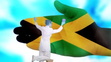 Tıbbi maskeli ve eldivenli hemşire, Jamaika bayrağı renginde boyanmış büyük elleri yıkıyor. Ulusal sağlık hizmetleri. Ellerinizi yıkayın. Virüs koruması. Hastalıkların önlenmesi.