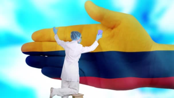 Νοσοκόμα με ιατρική μάσκα και γάντια πλένει το μεγάλο χέρι, βαμμένο σε χρώματα της Κολομβίας σημαία. Κρατική φροντίδα για την υγεία του έθνους. Πλύνε τα χέρια σου. Προστασία από ιούς. Πρόληψη ασθενειών. — Αρχείο Βίντεο