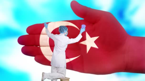 Pielęgniarka w masce medycznej i rękawiczkach myje dużą dłoń, malowaną w kolorach flagi Turcji. Opieka państwowa nad zdrowiem narodowym. Umyj ręce. Ochrona wirusów. Zapobieganie chorobom. — Wideo stockowe