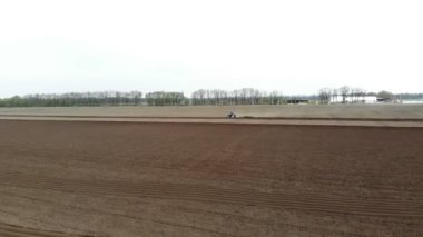 Havacılık. Bahar güneşli bir gün. Tarımsal bir tarlada traktör toprak, toprak ve modern tarım sürüyor. Eko çiftliği.