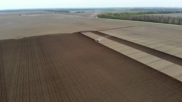 Aero. spring sunny day. On an agricultural, farming field, a tractor plows land, soil. Automated planting of potatoes on farms. modern agriculture. Eco farm. — Stock Video