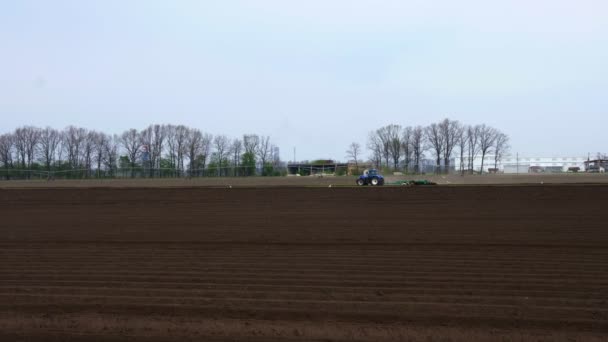 A traktor szántja a földet, a talajt a mezőgazdaságban, a mezőgazdaságot, előkészíti a földet a vetésre. modern mezőgazdaság. Öko farm. - Burgonyatermesztés. tavaszi napsütéses nap. — Stock videók