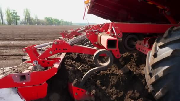 Primer plano, cultivador planta automáticamente patatas en filas de suelo recto en el campo de la granja, añade fertilizantes minerales al suelo, para un mejor crecimiento de la patata. agricultura moderna. Primavera día soleado — Vídeo de stock