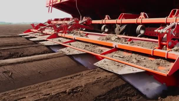 Primer plano, cultivador planta automáticamente patatas en filas de suelo recto en el campo de la granja, añade fertilizantes minerales al suelo, para un mejor crecimiento de la patata. agricultura moderna. Primavera día soleado — Vídeo de stock