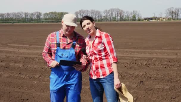 Interviewt der Journalist den Bauern für eine Fernsehberichterstattung über den modernen landwirtschaftlichen Anbau. Hintergrund des neu gepflügten landwirtschaftlichen Feldes. — Stockvideo