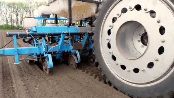 Close-up van Tractor met zaaimachine in het veld. Zaaien van maïs, Maïs in de bodem, met pneumatische zaaimachine tijdens het voorjaarsseizoen. landbouwer op trekker met zaaimachine verwerkt het veld. — Stockvideo