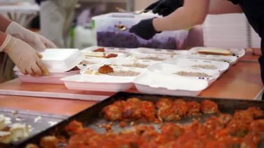 Gönüllüler, fakir ve evsiz insanlara Covid19 'un tecridi sırasında bedava sıcak yemek paketleri hazırlıyorlar. Yemek servisi. Yardım projesi, bağış yardımı,