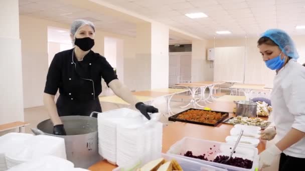 CHERKASY, UKRAINE, 18 MAI 2020 : Les bénévoles emballent des repas chauds gratuits dans des boîtes à lunch, à livrer aux pauvres et aux sans-abri pendant le confinement de la covid19. Projet caritatif, don d'aide, livraison de nourriture — Video