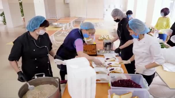 CHERKASY, UKRAJINA, 18. KVĚTNA 2020: Dobrovolníci balí teplá jídla zdarma do krabic s obědem, které mají být doručeny chudým a bezdomovcům během uzamykání smluvní smlouvy19. Charitativní projekt, dárcovská pomoc, dodávky potravin — Stock video