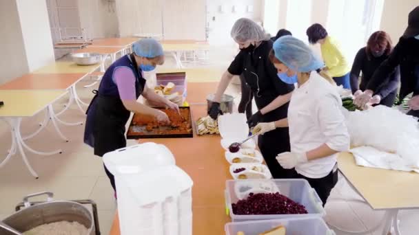 CHERKASY, UKRAINE, 18 MAI 2020 : Les bénévoles emballent des repas chauds gratuits dans des boîtes à lunch, à livrer aux pauvres et aux sans-abri pendant le confinement de la covid19. Projet caritatif, don d'aide, livraison de nourriture — Video