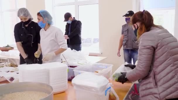 CHERKASY, UKRAINE, 18 MAI 2020 : Les bénévoles emballent des repas chauds gratuits dans des boîtes à lunch, à livrer aux pauvres et aux sans-abri pendant le confinement de la covid19. Projet caritatif, don d'aide, livraison de nourriture — Video