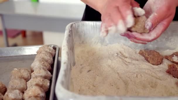 Närbild, en kvinnlig kock lagar köttbullar, doppar bollar av malet kött i mjöl och sprider det på en bakplåt. — Stockvideo