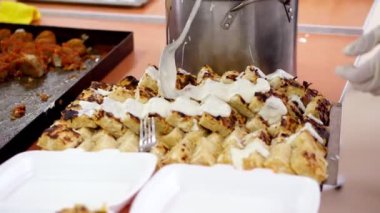 Yakın plan, taze pişmiş kaymak güvecine beyaz krema serpiştirmek. Umumi kantinde mutfak. Gönüllüler fakir ve evsizler için hayır yemeği pişiriyor. Bedava yemek servisi. bağış yardımı, Charity