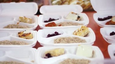 Yakın plan, tek kullanımlık eldivenler, yardım çantalarına sıcak yemek doldurur. Gönüllüler tarafından 19. koğuş boyunca fakir insanlara ücretsiz teslim edilir. Yemek servisi..