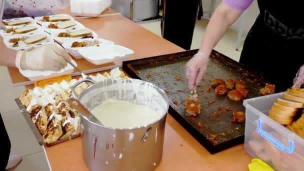 Aus nächster Nähe packen Freiwillige kostenlose warme Mahlzeiten in Lunchboxen, die während der Covid19-Sperre an arme Menschen ausgeliefert werden. Essensausgabe. Wohltätigkeitsprojekt, Hilfe spenden, — Stockvideo