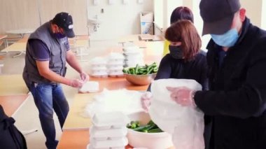 CHERKASY, UKRAINE, 18 Mayıs 2020: Gönüllüler, Covid19 'un tecridi sırasında fakir ve evsizlere teslim edilmek üzere yemeklerle birlikte sadaka paketleri hazırlıyorlar. Yemek servisi. Yardım projesi, bağış yardımı