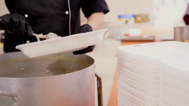 Gros plan, femme Volontaire en gants noirs met de la bouillie dans des boîtes à lunch de grande casserole. Repas chauds caritatifs pour les pauvres et les sans-abri. Livraison gratuite de nourriture. don d'aide , — Video