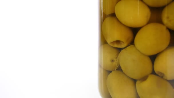 Close-up, pickled large green olives in a glass jar, food product rotate on white background. grocery online shopping. food delivery, food preservation — Stock Video