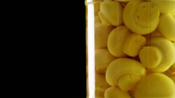 Close-up, pickled mushrooms champignons in a glass jar, food product rotate on black background. grocery online shopping. food delivery. food preservation — Stock Video