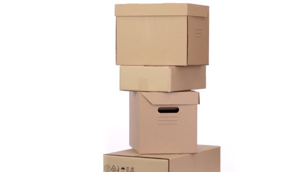 Karton kutular birbirinin üstünde durur, beyaz bir arka planda döner. İnternetten alışveriş. Teslimat. Market ya da bağış kutuları. Paket yemek, mal teslimatı — Stok video