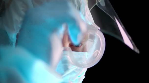 Портрет чоловіка-медика. Виснажений і втомлений лікар знімає захисну форму від коронавірусу, маску, окуляри і захисний екран. пандемія ковадла-19 — стокове відео