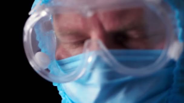 男性医療従事者の肖像画。疲れと疲れ医師は、コロナウイルス保護制服、マスク、眼鏡や保護画面を離陸。パンデミックコビト-19 — ストック動画