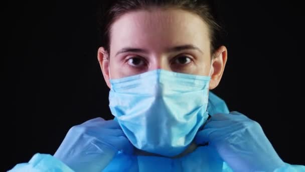 Portret van een vrouwelijke arts. Dokter kleedt zich beschermend uniform, masker, bril. een pandemische covid-19, uitbraak. Bescherming van het coronavirus — Stockvideo