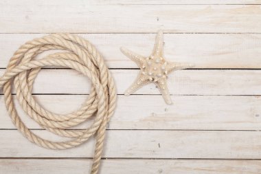 İp ve denizyıldızı ahşap arka plan üzerinde