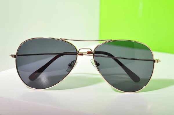 Сонцезахисні окуляри на білому і зеленому тлі — стокове фото