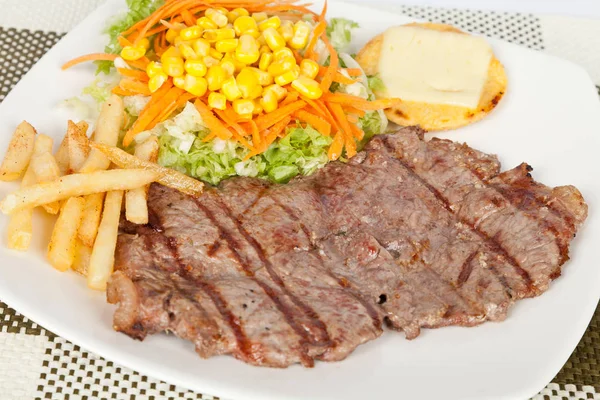 Carne grelhada com batatas fritas e salada — Fotografia de Stock