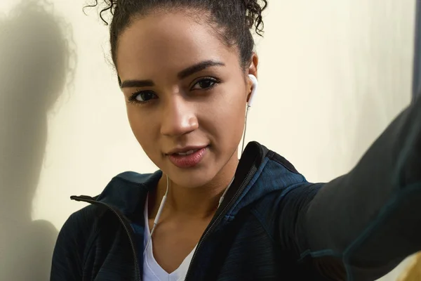 Woman in sports clothes taking selfie after workout, close up