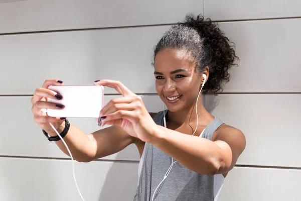 Young woman taking a selfie after workout, live streaming for social media