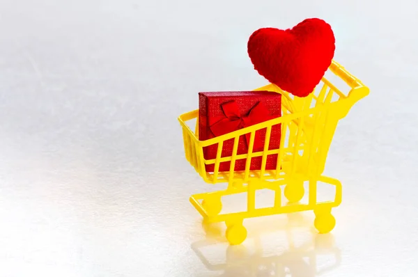 Bevásárlókosár piros jelen doboz és konfetti piros szív egy — Stock Fotó