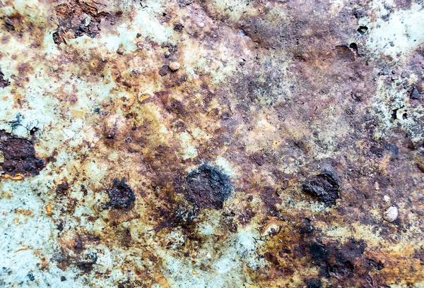 Rough and battered green paint texture on a rusted metal surface