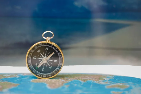 Boussole magnétique sur carte du monde, concept de voyage et de destination — Photo