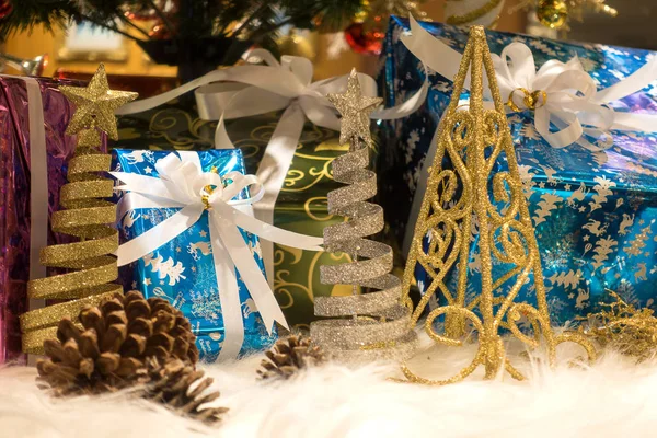 Caixas de presente de Natal bonitas no chão perto de abeto no quarto — Fotografia de Stock