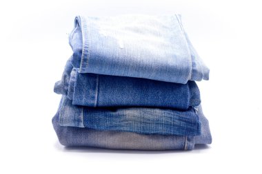 Beyaz arka plan üzerine yığılmış kot pantolon