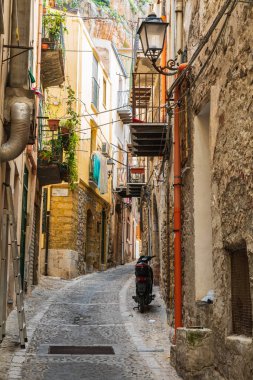 İtalya, Sicilya, Palermo Eyaleti, Cefalu. Cefalu kasabasında dar bir sokağa park edilmiş bir scooter..