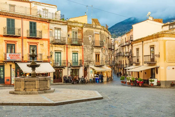 İtalya, Sicilya, Palermo Eyaleti, Castelbuono. 11 Nisan 2019. Castelbuono Meydanı 'ndaki çeşme ve kafeler.