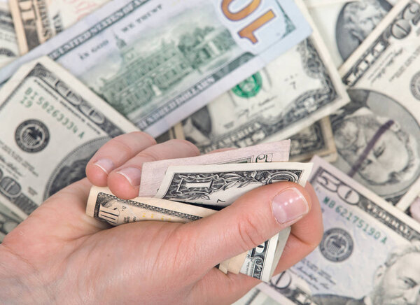 Human hand counting us dollar bills