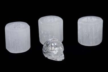 White selenite cylinder tea light holders with clear quartz skull clipart