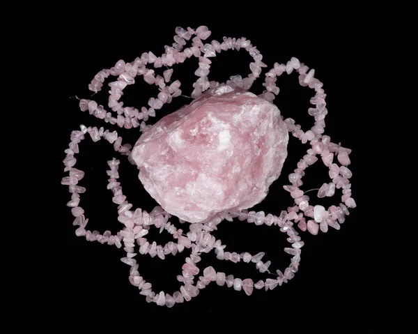 Raw rose quartz from Madagascar and polished rose quartz strings — Stock Photo, Image