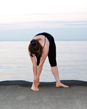 Güneş doğarken genç aktif kadın germe yapmak egzersizleri